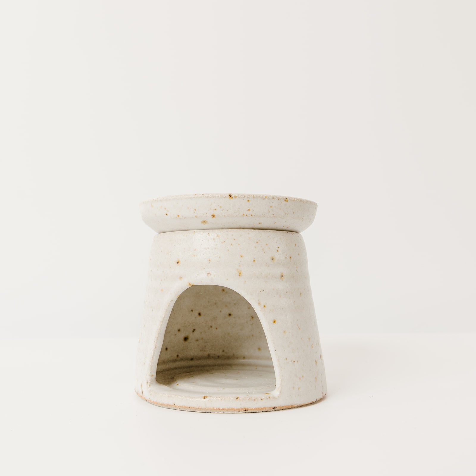 Speckled ceramic oil burner on a white background
