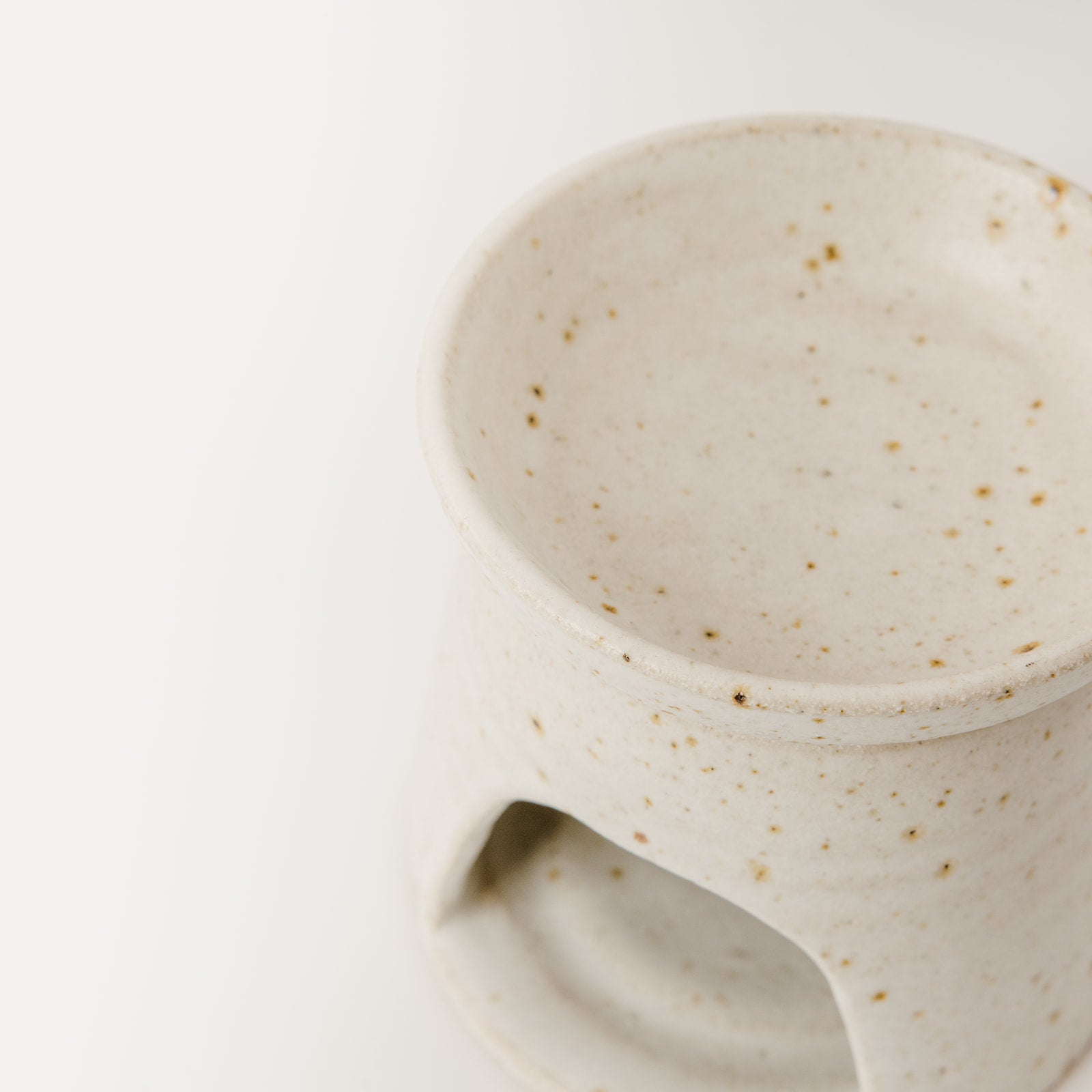 Close up view of a hand thrown wax melt burner lid and front view. Made using specked stoneware clay pictured on a white background.