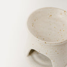 Close up view of a hand thrown wax melt burner lid and front view. Made using specked stoneware clay pictured on a white background. 