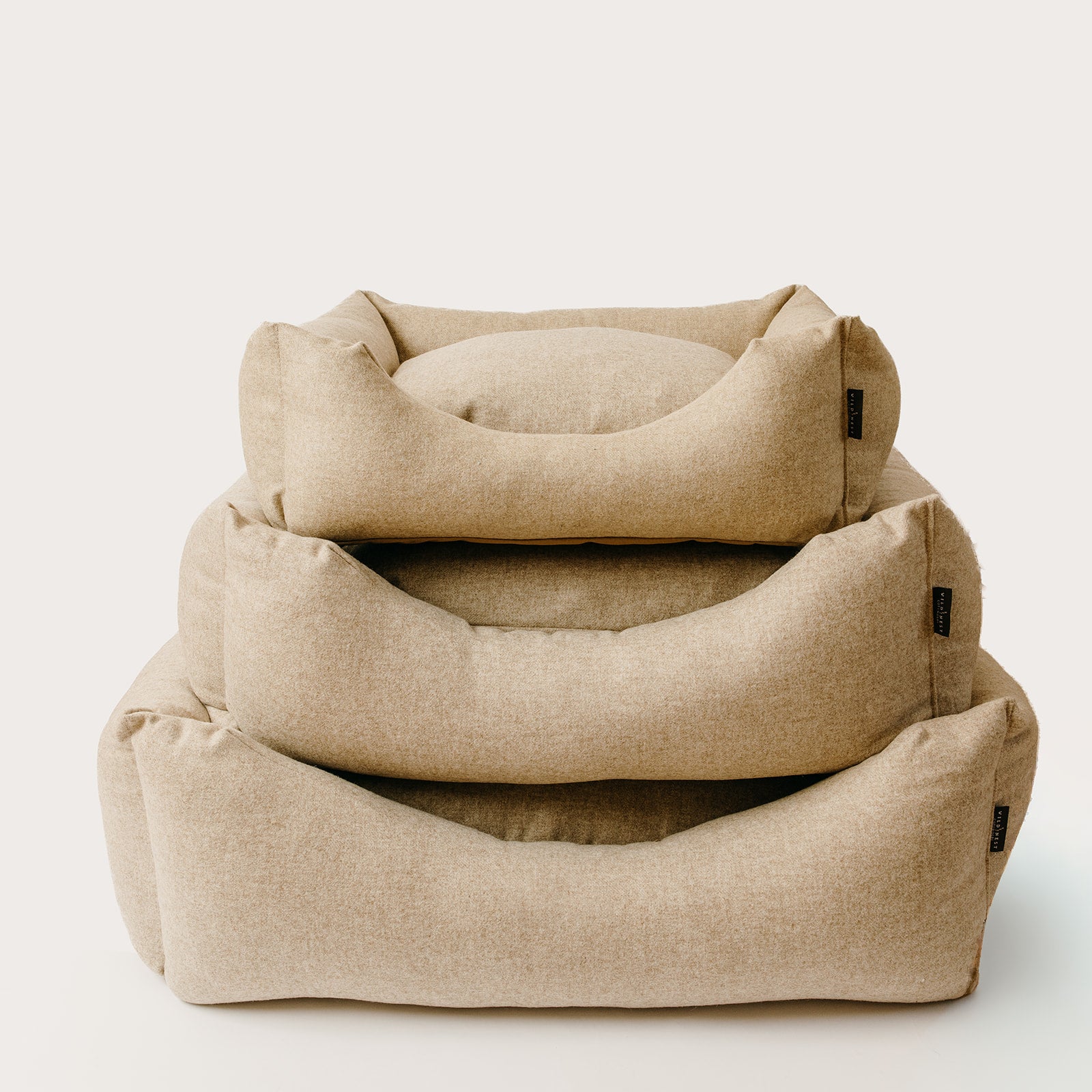 Pure new wool dog beds with multiple sizes stacked on a white background, handmade in England, wild nest Cotswolds 