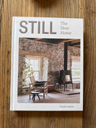 Book titled 'The STILL Slow Home' on a wooden surface