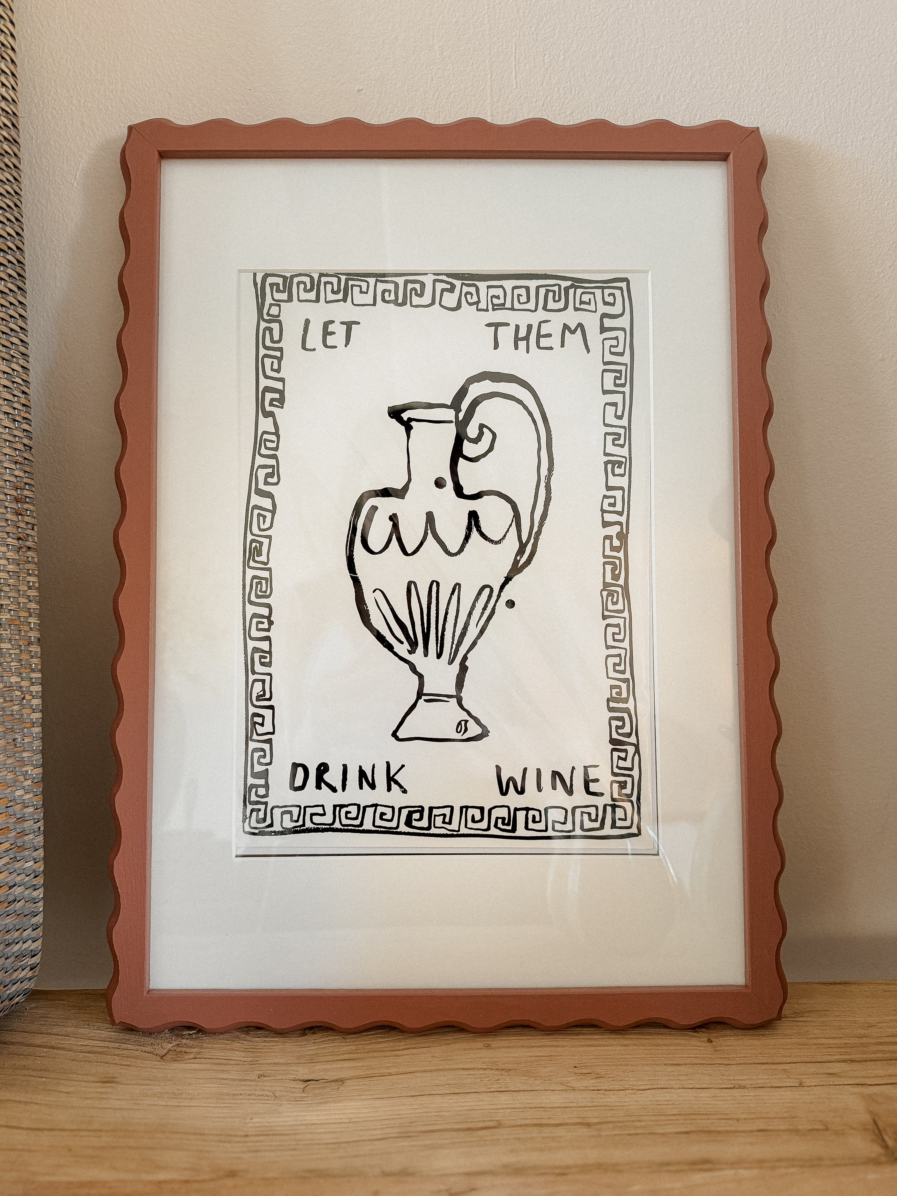 Framed art print by English artist Olivia Sewell in a painted wiggle frame sat on a wooden table top 